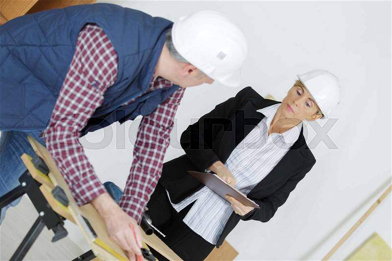 Worker with overseer controling stock in warehouse, stock photo