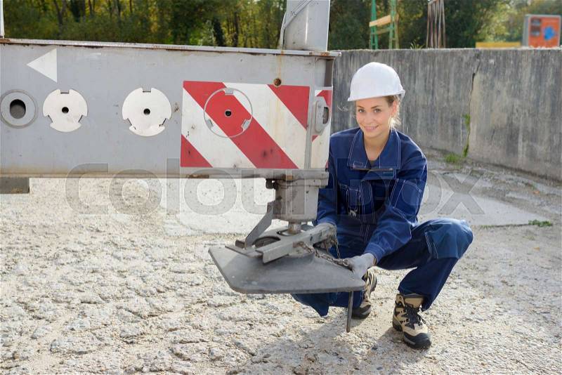 Lady securing balancing foot of crane, stock photo