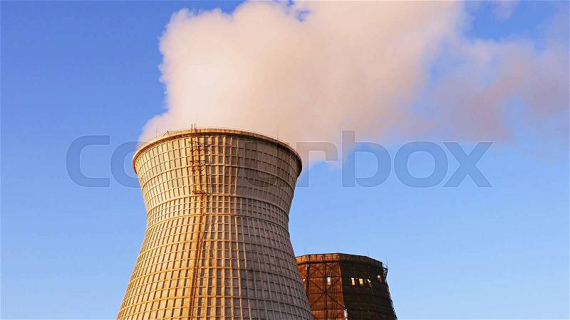 Water cooling tower stack smoke over blue sky background. Energy generation and air environment pollution industrial scene, stock photo