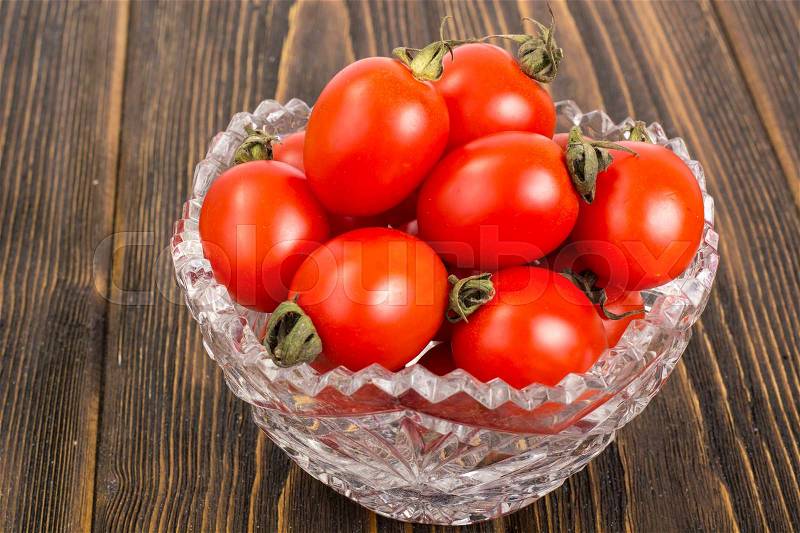 Small red tomatoes in crystal bowl. Studio Photo, stock photo