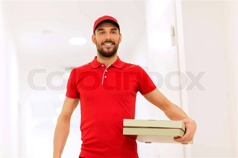 Food delivery, mail and people concept - happy man delivering pizza in paper boxes, stock photo