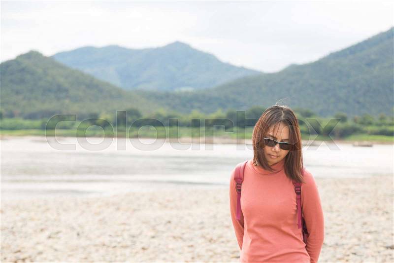 Asian woman wear sunglasses and thinking . after mountain and river, stock photo