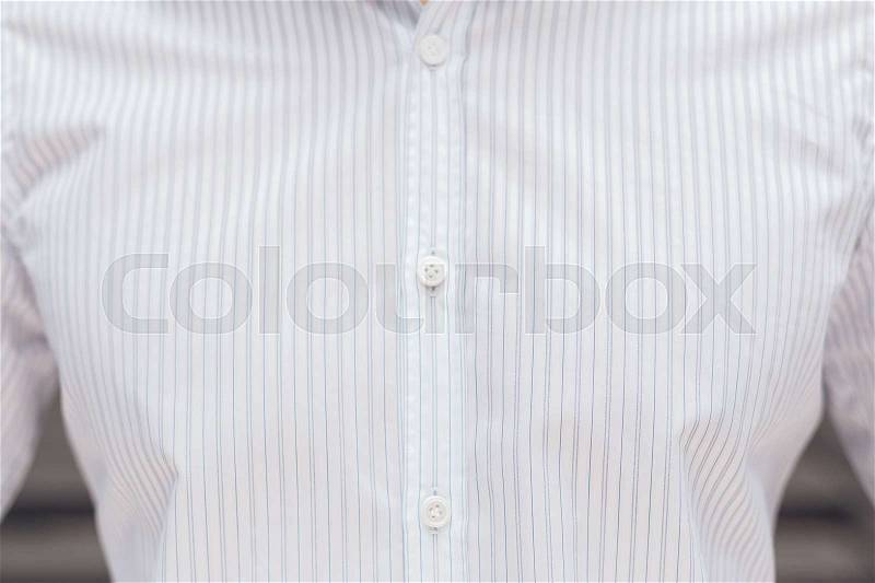 Close up part of a white business shirt on a man. Elegant beautiful shirt with buttons, stock photo