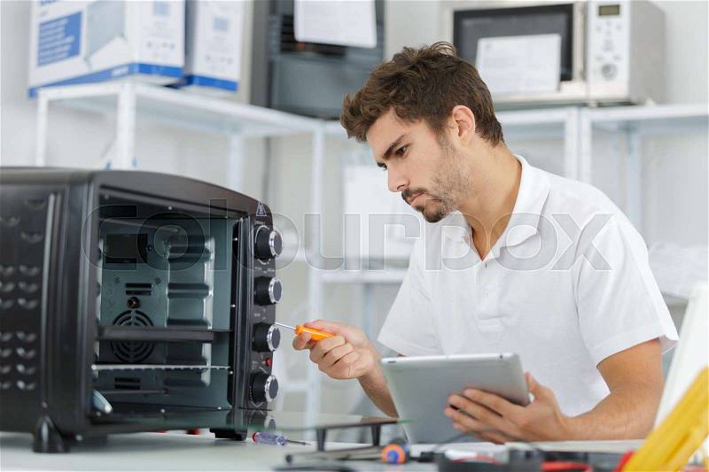 Attractive repairman concentrated at work, stock photo