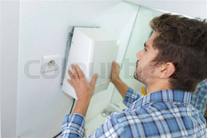 Installation of hand-dryer in office, stock photo