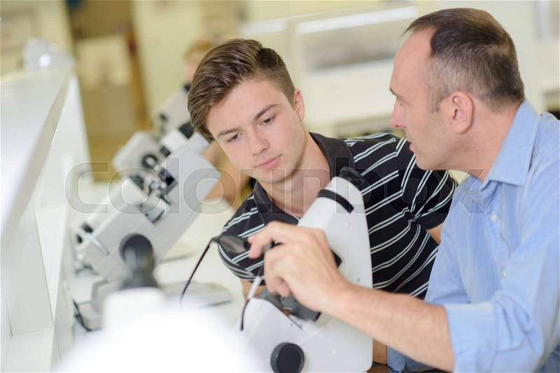 Teacher and student looking at lens, stock photo