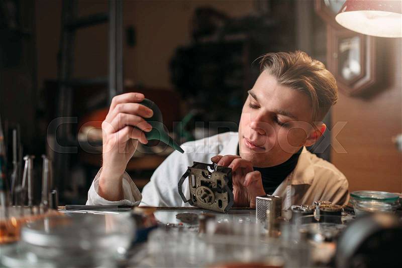 Watchmaker cleans the mechanism of old watches. Clock maker at work, stock photo