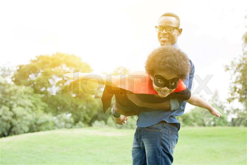 Father holding and helping flying super hero kid togehter in happiness, stock photo