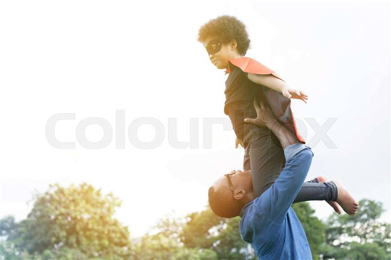 Father holding and helping flying super hero kid togehter in happiness, stock photo