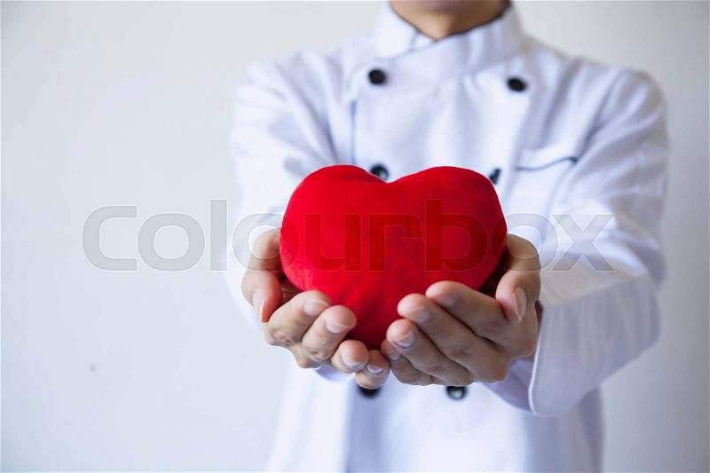 Happy chef holding heart shape with love and passion, stock photo
