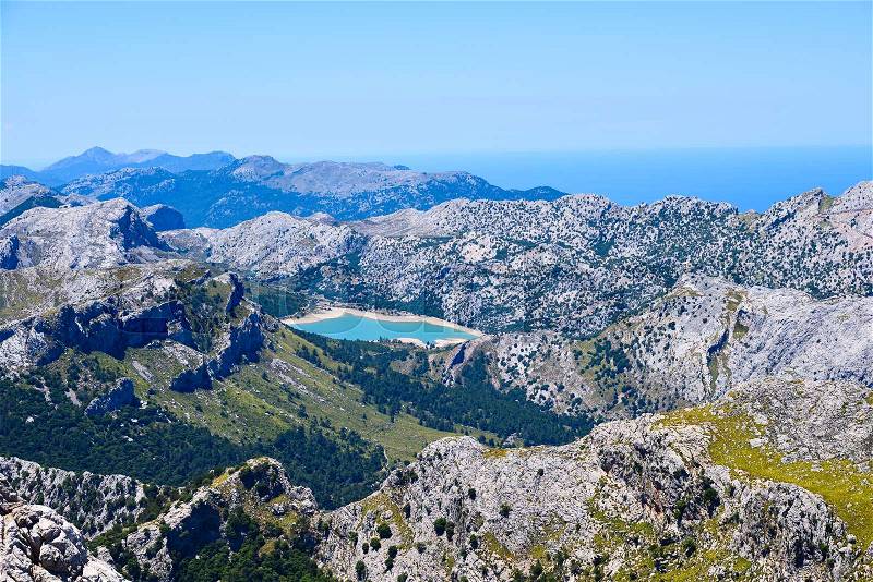High mountains range with a blue lake on the island of Mallorca, stock photo