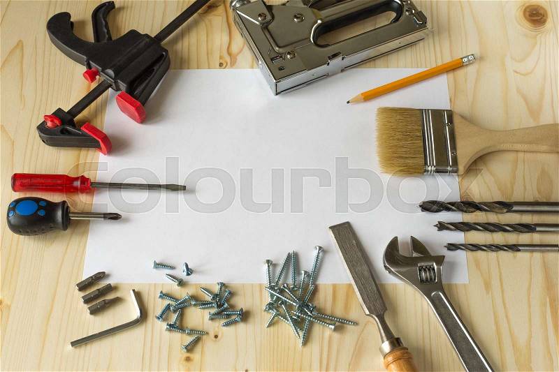 Tools for repairs in the house on a wooden table. Screws, screwdrivers, clamps, stock photo