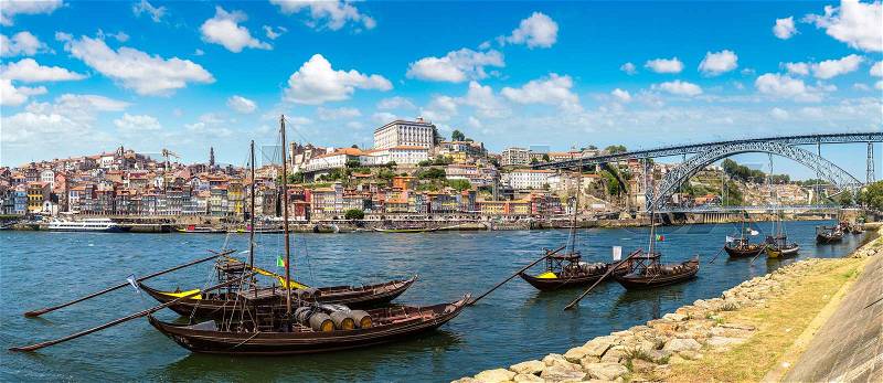 Traditional boats with wine barrels and Douro River in Porto in a beautiful summer day, Portugal, stock photo