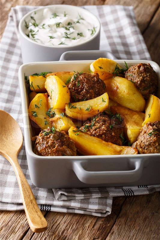 Potato wedges and meatballs, herbs in a dish close-up on the table. vertical , stock photo