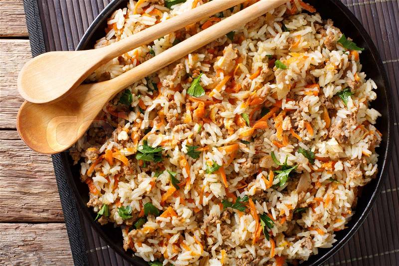 Fried spicy rice with minced meat and vegetables close-up on the table. horizontal view from above , stock photo