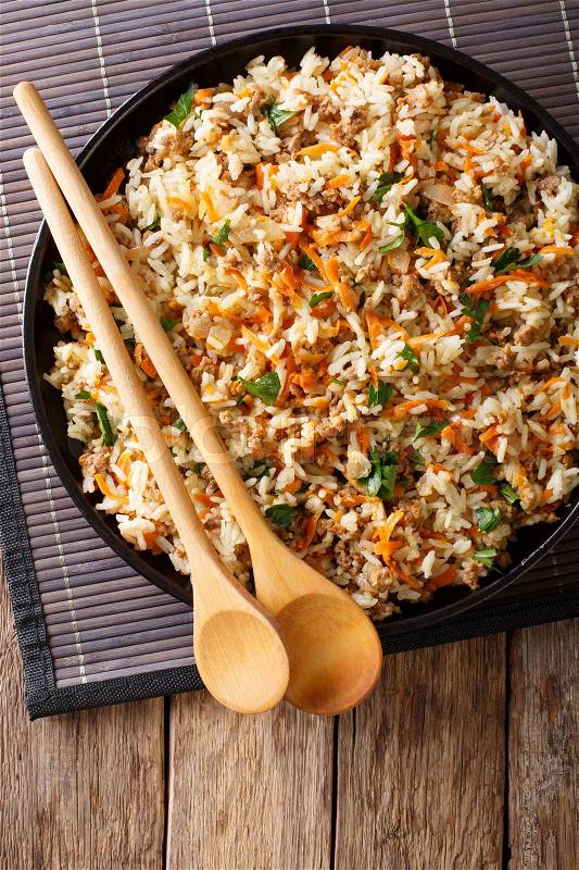 Thai spicy rice with minced meat and vegetables close-up on the table. vertical view from above , stock photo