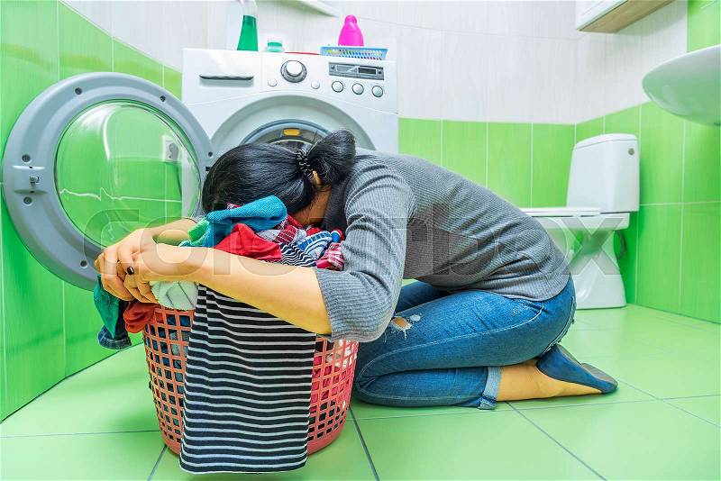 Woman tired of washing. She\'s lying on the laundry basket, stock photo