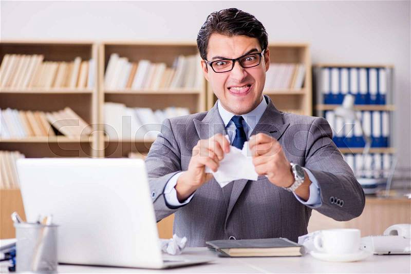 Angry businessman with too much work in office, stock photo