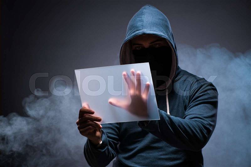 Hacker working on tablet in dark, stock photo