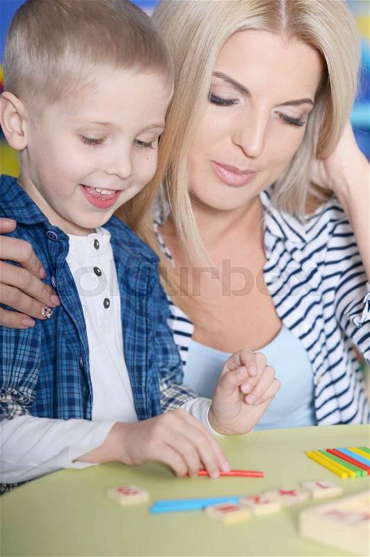 Portrait of a mother helping her son with lessons, stock photo