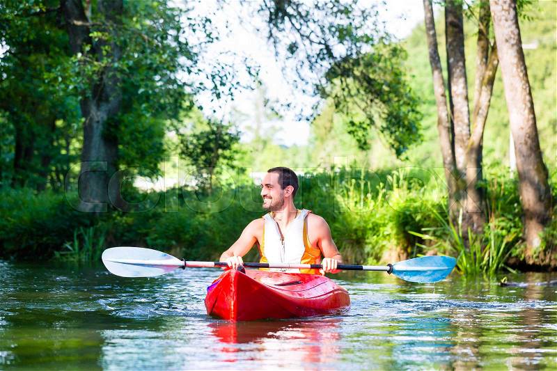 Man paddling with canoe or kayak on river, stock photo