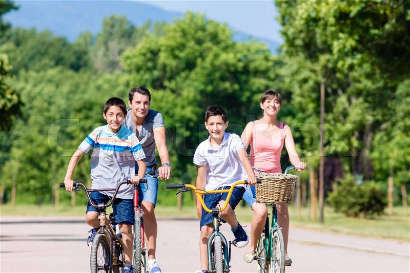 Family of four on bike tour in summer, stock photo