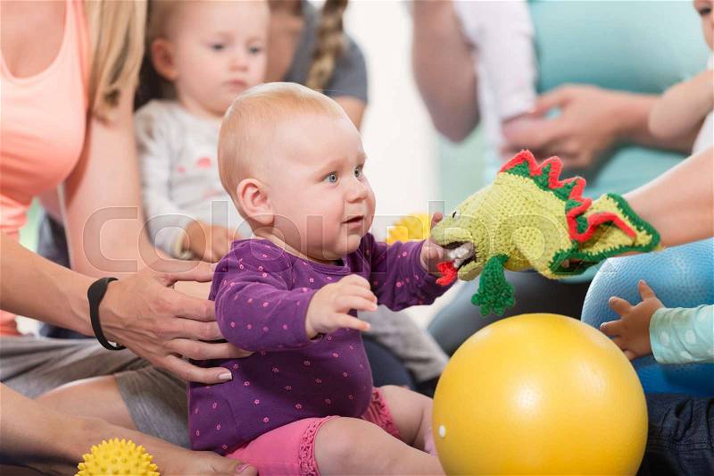 Young women in mother and child group playing with their baby kids, stock photo