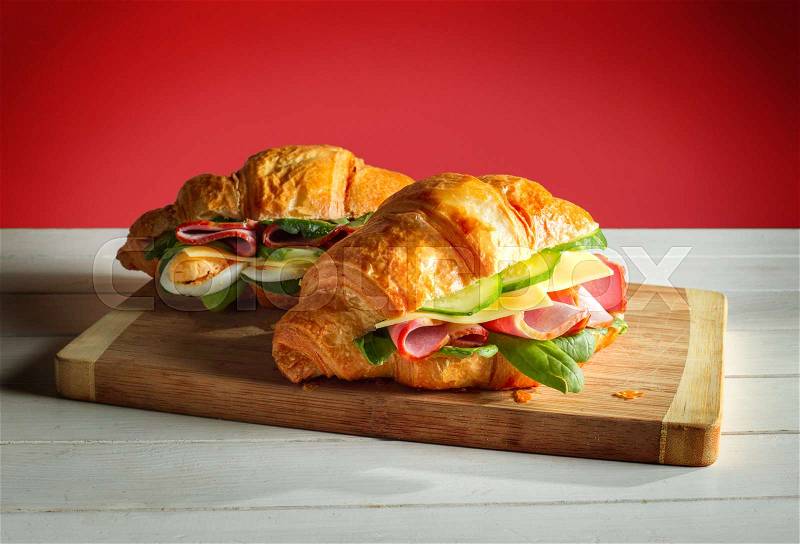 Croissants sandwiches on the wooden cutting board, stock photo