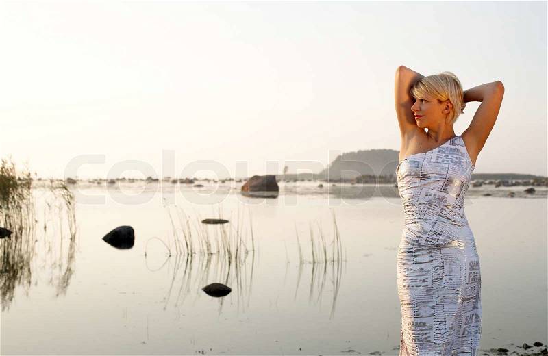 Pretty blond in fancy dress at the seashore, stock photo