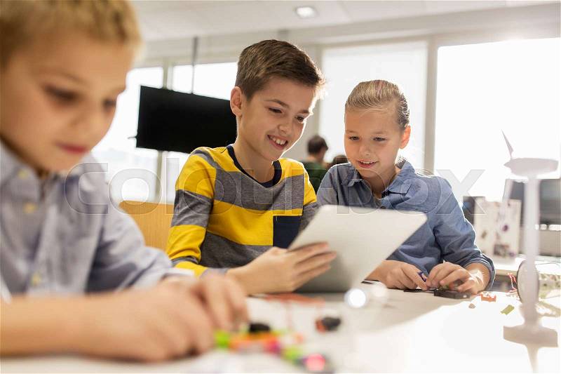 Education, science, technology, children and people concept - group of smiling kids or students with tablet pc computer programming at robotics school lesson, stock photo