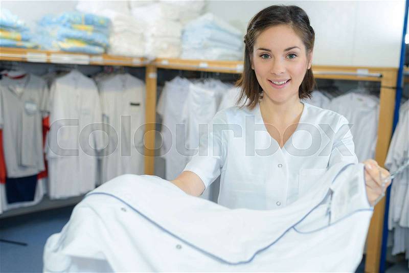 Beautiful young woman working at laundry, stock photo