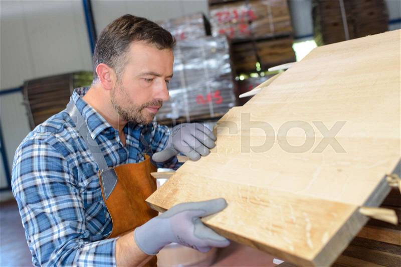 Wood barrels production cooper using hammer and tools in workshop, stock photo