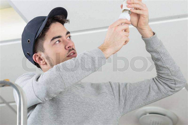 Man changing light bulb, stock photo
