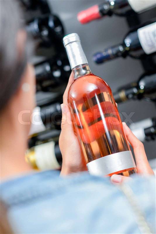 Selecting a bottle of wine, stock photo