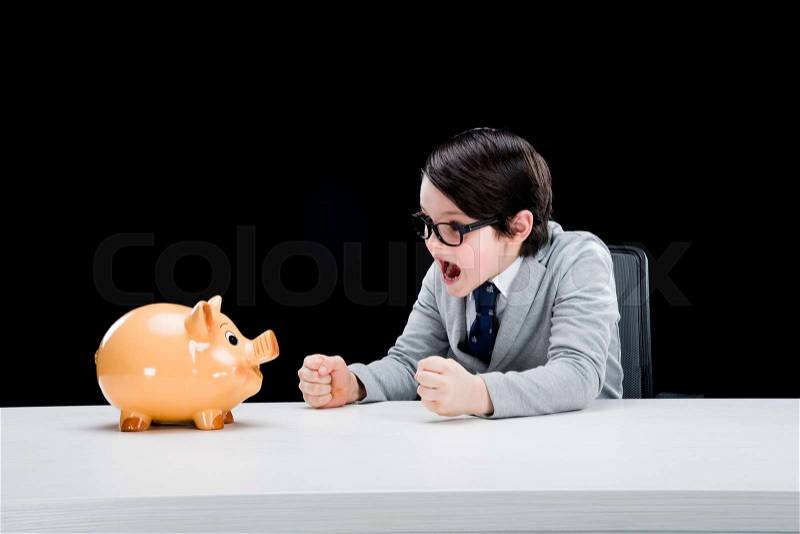 Little boy businessman shouting at piggy bank, stock photo