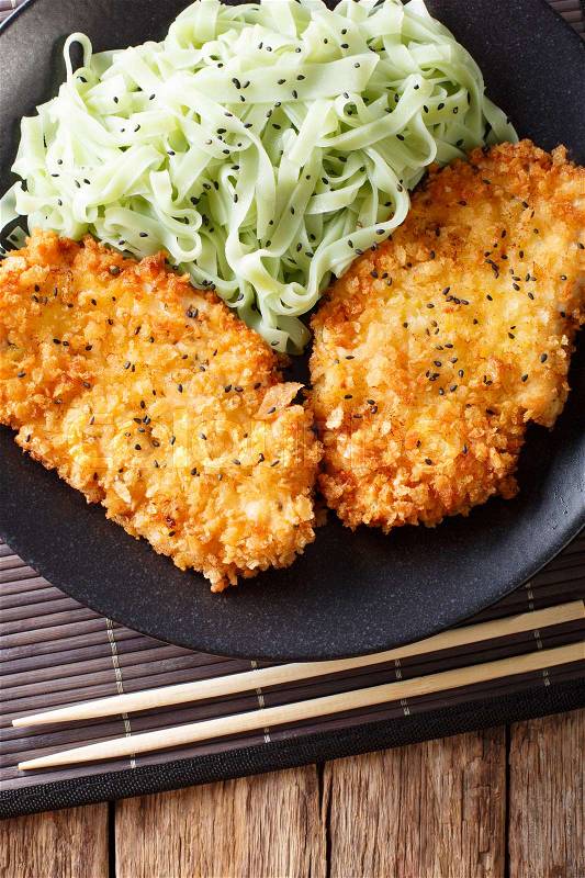 Chicken cutlet in breadcrumbs and noodles with green tea Macha on the table. vertical view from above , stock photo