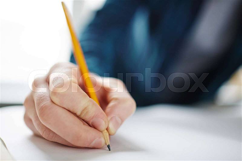 Closeup of male hand holding pencil on blank paper, drawing or writing, stock photo
