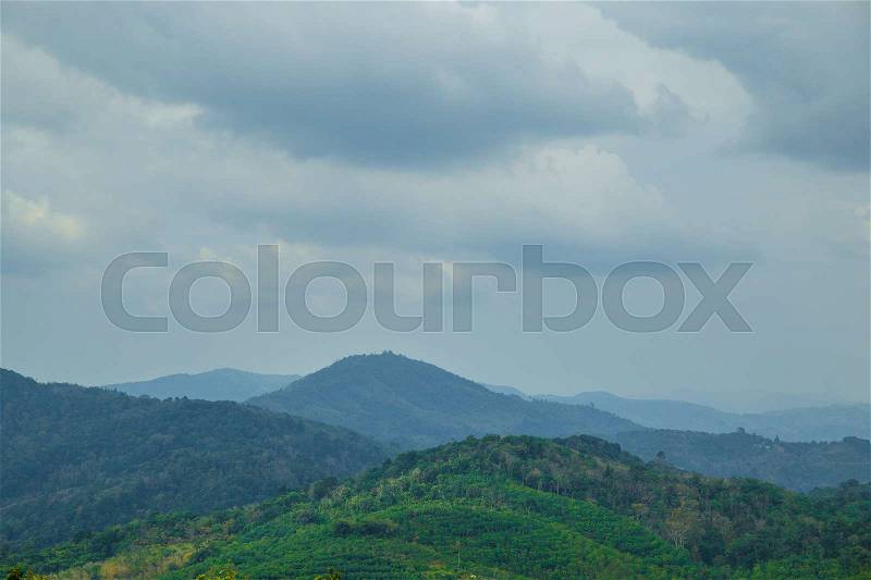 Forest green mountains in the grey dark clouds morning, stock photo