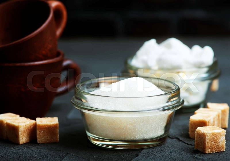 Sugar in bowl and on a table, stock photo