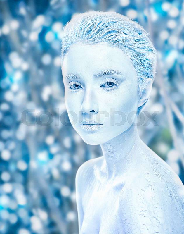 Attractive naked covered in ice woman with snowy winter forest on background. Sensuality frosted girl. Snow frozen female, cold effect concept. Snow-covered makeup beauty, stock photo