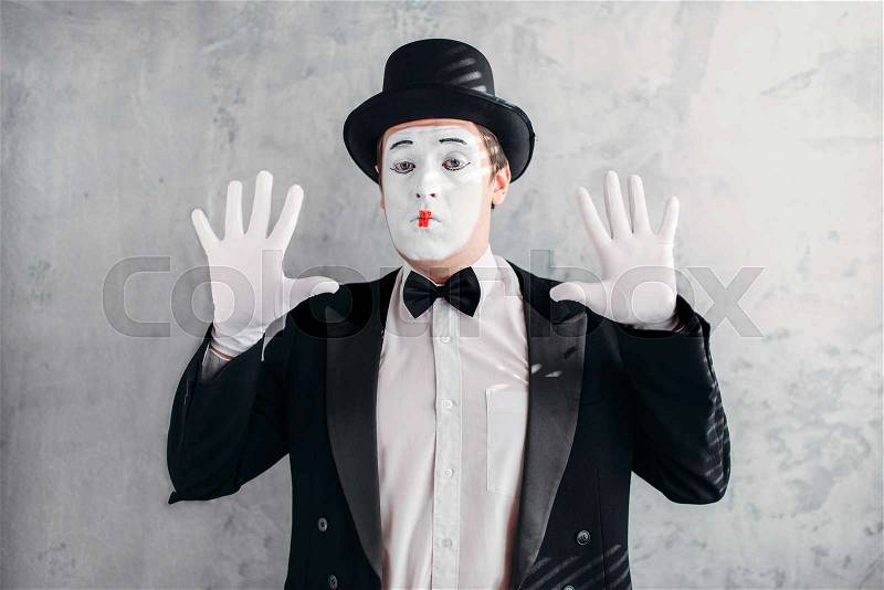 Funny mime actor with makeup mask. Pantomime in suit, gloves and hat. April fools day concept, stock photo