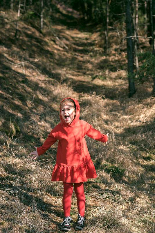 Portrait of scared little girl in the woods, stock photo