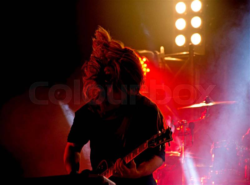 Rock concert stage. Guitarist playing on electric guitar, stock photo