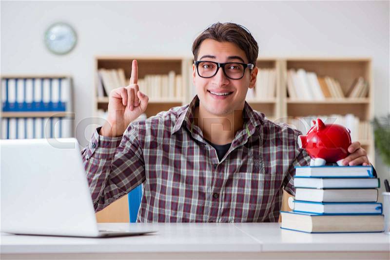 Student breaking piggybank to pay for tuition fees, stock photo