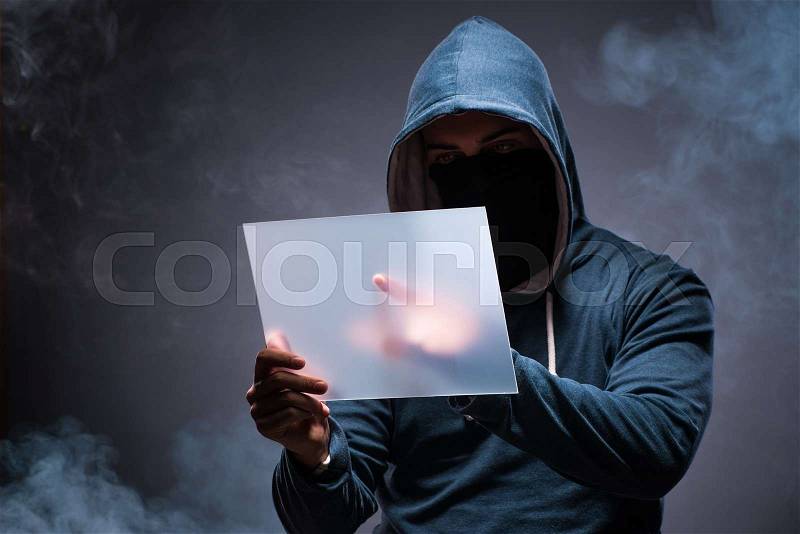 Hacker working on tablet in dark, stock photo