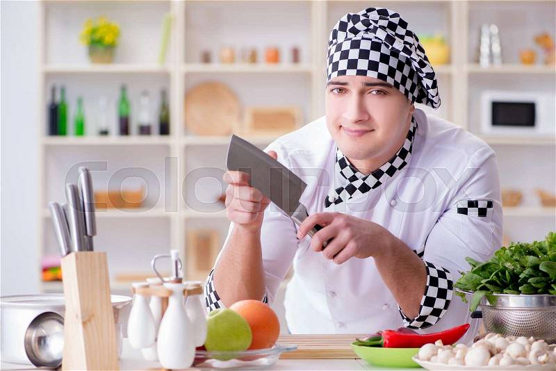 Young male cook working in the kitchen, stock photo