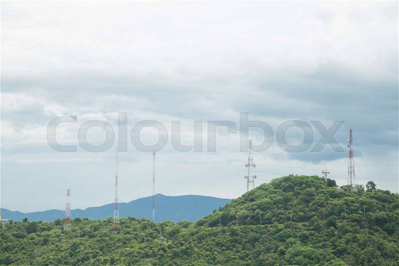 Signal towers of communication systems on the top of the hill and in the forest, stock photo