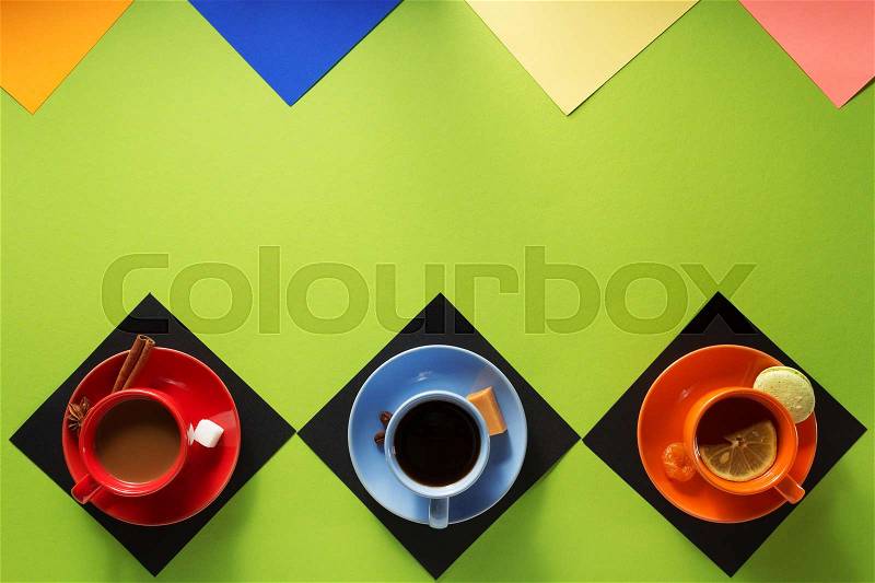 Cup of coffee, tea and cacao at colorful paper background, stock photo