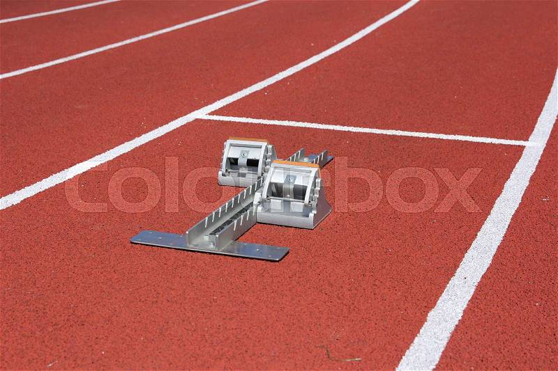 Athletics starting blocks on race red track, stock photo
