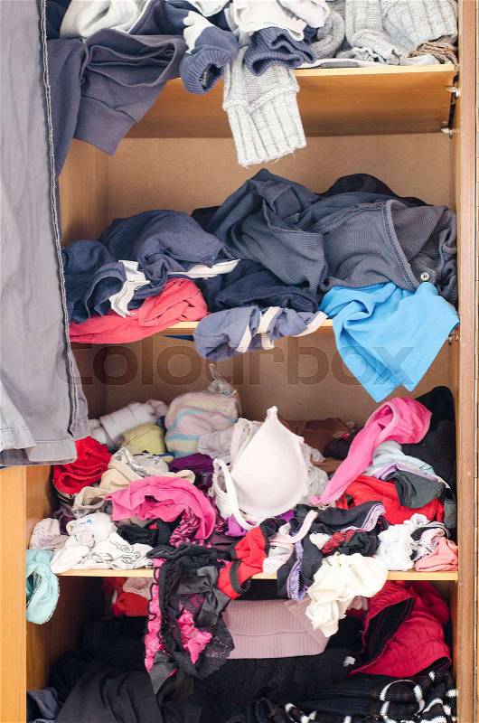 Pile of carelessly scattered clothes in wardrobe, stock photo